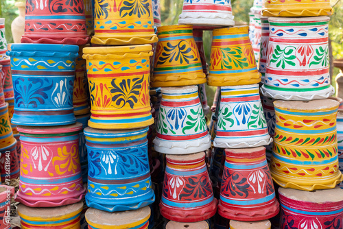 Colorful painted plant pots at a garden center display for sale.