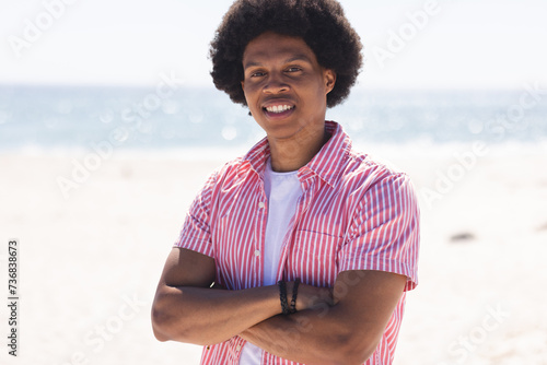 A young African American man smiles at the beach