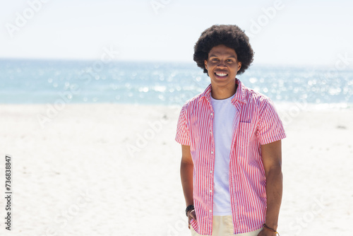 A young African American man smiles at the beach, with copy space unaltered