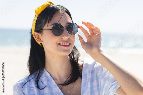 Young biracial woman enjoys a sunny beach day unaltered