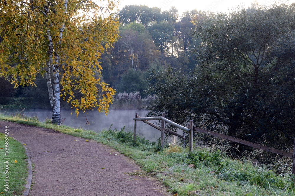 Foggy Morning in Autumn at Lake Klostersee in the Town Walsrode, Lower Saxony Foggy Morning in Autumn at Lake Klostersee in the Town Walsrode, Lower Saxony