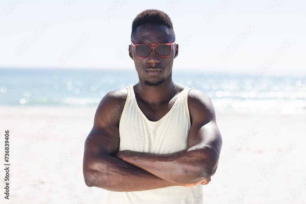 Fototapeta premium Young African American man stands confidently on the beach