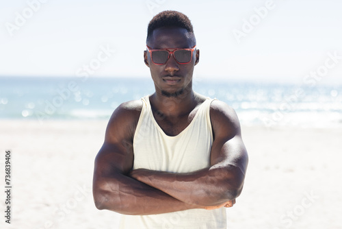 Young African American man stands confidently on the beach