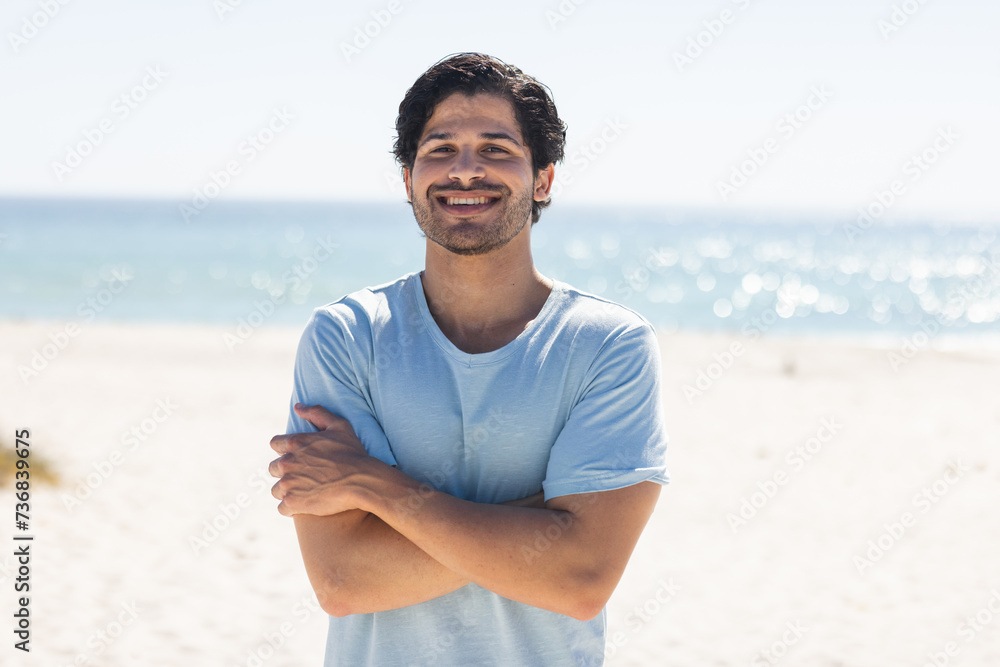 Naklejka premium Young biracial man smiles at the beach