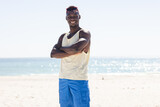 Young African American man stands confidently on the beach