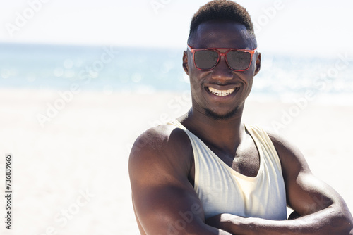 Young African American man enjoys the sun at the beach