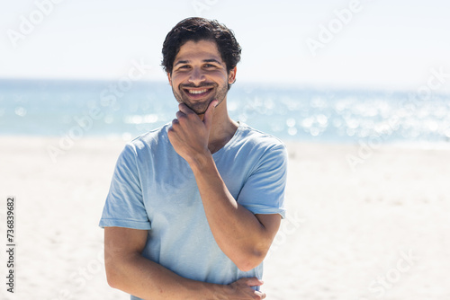 A young biracial man smiles at the beach