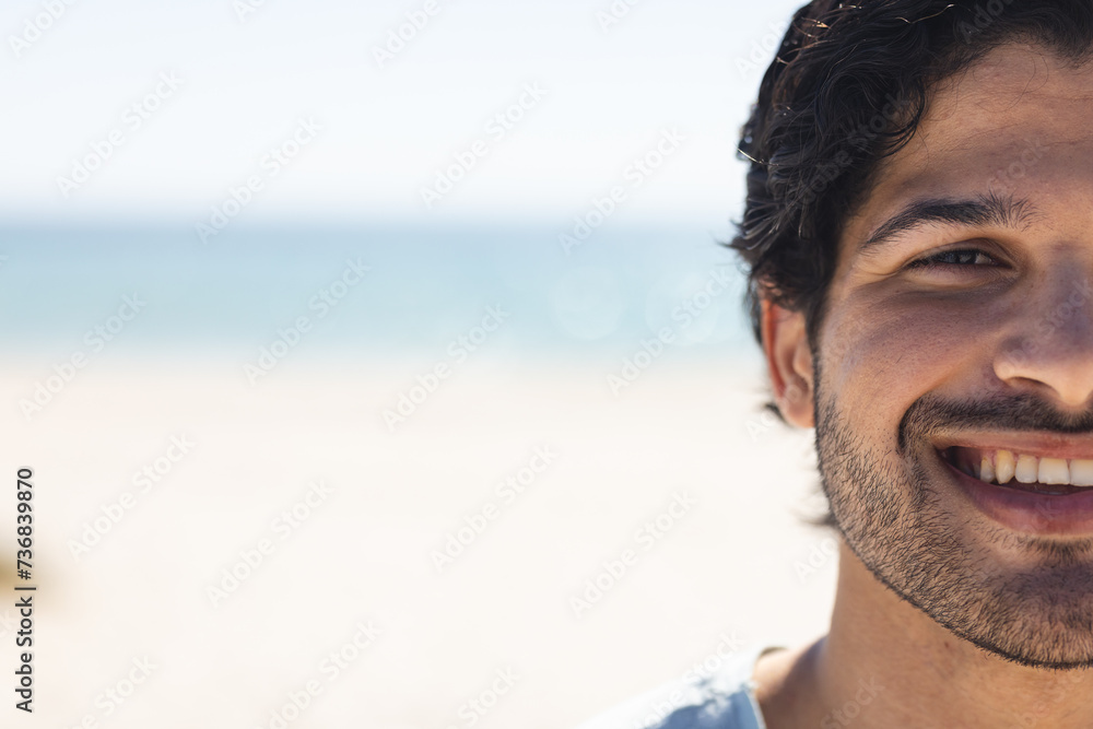 Young biracial man smiles brightly at the beach, with copy space Young biracial man smiles brightly at the beach, with copy space