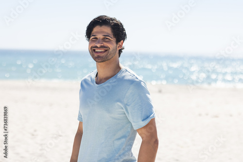 Young biracial man enjoys a sunny day at the beach