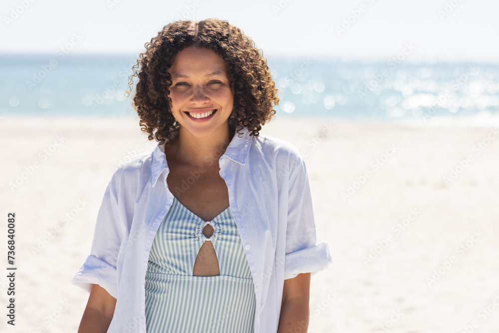 Fototapeta premium Young biracial woman enjoys a sunny beach day