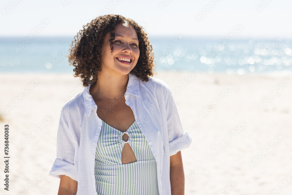 Fototapeta premium Young biracial woman enjoys a sunny beach day