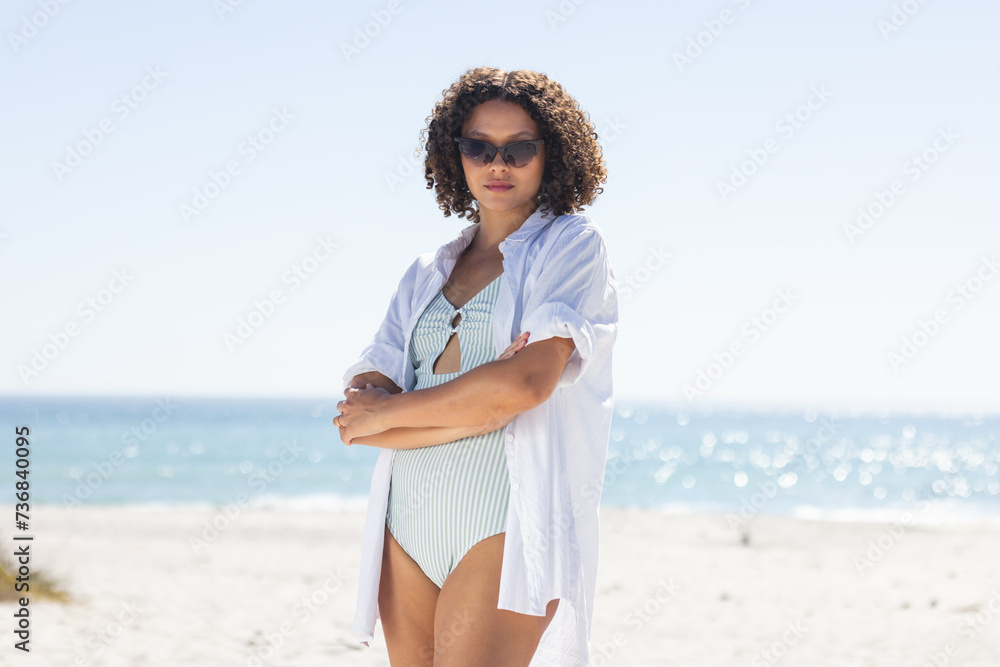 Fototapeta premium Young biracial woman stands confidently on the beach