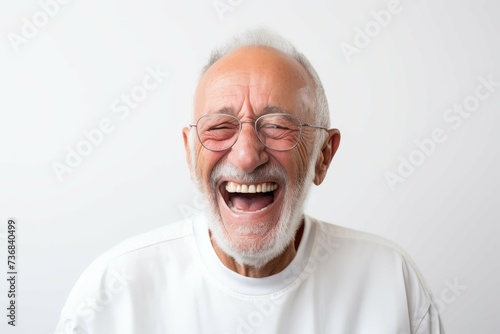 Portrait of an elderly man laughing heartily with joy and happiness.