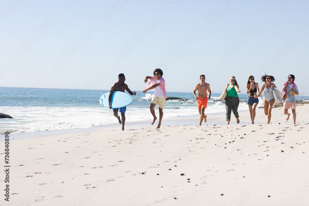 Fototapeta premium Diverse group of friends enjoy a day at the beach with copy space