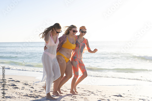 Three friends enjoy a sunny beach day, with copy space