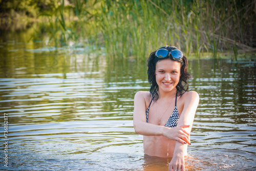Fototapeta Naklejka Na Ścianę i Meble -  A girl with a beautiful body bathes in the river in summer.