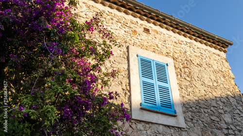 provence wooden window blue shutter on stone house facade in France