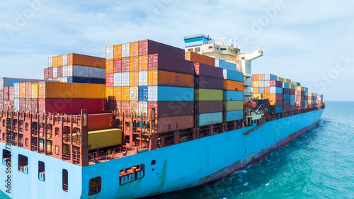 Stern of large cargo ship import export container box on the ocean sea on blue sky back ground concept transportation logistic and service to customer and supply change, webinar banner