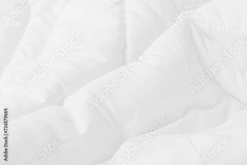 Close up top view of white bedding sheet and wrinkle messy blanket in bedroom after wake up in the morning. photo
