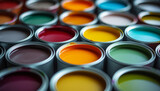 Multiple open paint cans in a variety of vibrant colors arranged closely, showcasing a spectrum of paint options.