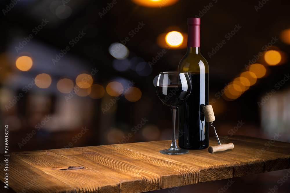 Bottle and glass of red wine on a red background. Copy space for your text. High quality photo