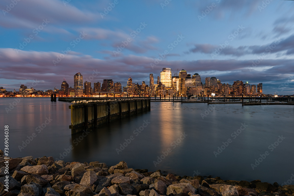 View of Manhattan skyline across the Hudson River from the waterfront Walkway in Jersey City at night