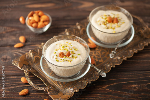 Traditional delicious Turkish Dessert Keskul with nuts in cream bowl photo