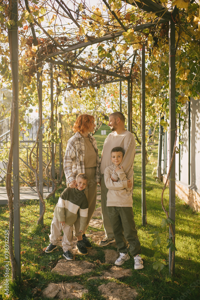 Fototapeta premium Happy family of father, mother and two sons spending time together outdoors.