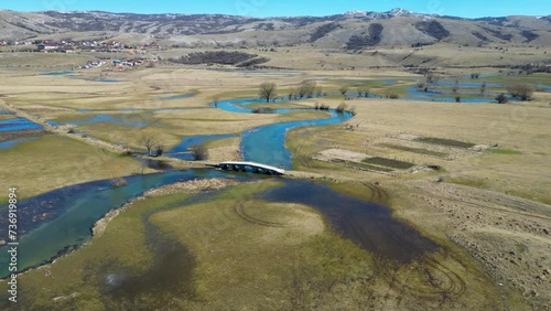 Aerial drone view of an amazing beautiful serpentine river. Vibrant colors and beautiful landscape. Background and textures. Nature and beautiful scenery. River Šuica in Bosnia and Herzegovina. 
 photo