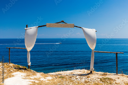 Obraz na płótnie Empty wedding gate made of sticks and located on coastline of the sea, decorated by white fabric. w salonie