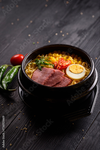 Korean food. Ramen with smoked beef. on a black wooden background
