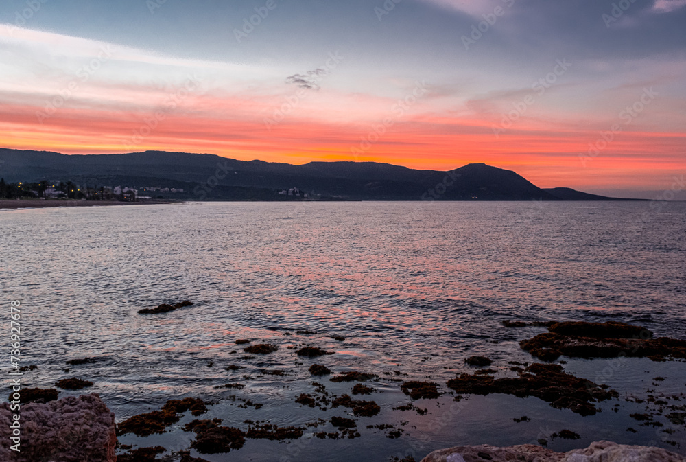 View of the Sunset at Chrysochou Bay as seen from Latsi village harbor, located by the sea, near Neo Chorio village, Akamas Peninsula, Cyprus View of the Sunset at Chrysochou Bay as seen from Latsi village harbor, located by the sea, near Neo Chorio village, Akamas Peninsula, Cyprus