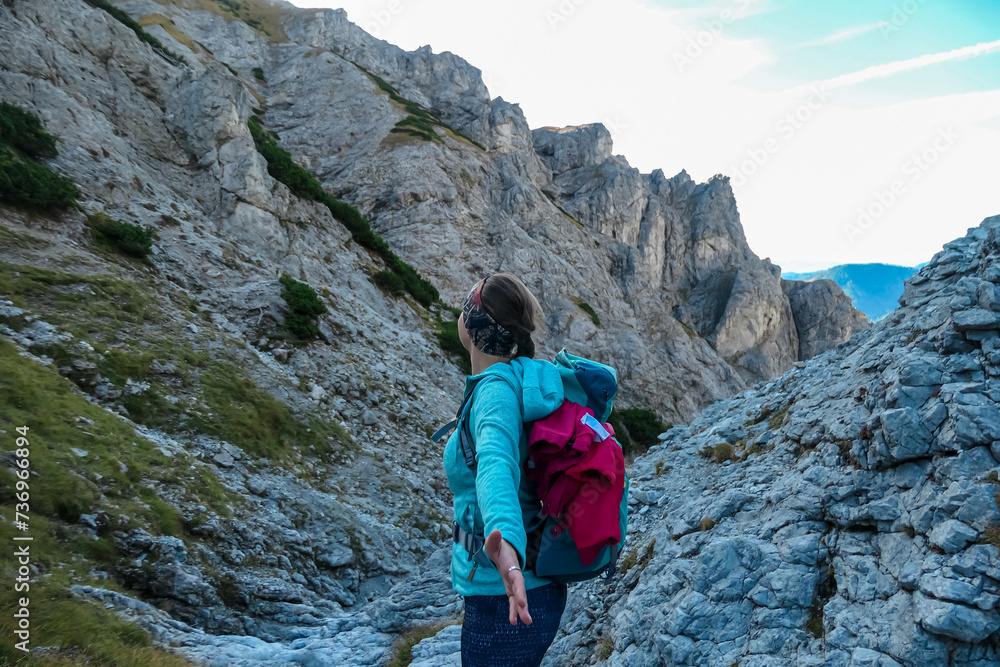 Hiker woman with panoramic view of majestic mountain cliff Schartenspitze in untamed Hochschwab mountain region, Styria, Austria. Scenic hiking trail in remote Austrian Alps. Wanderlust, alpine summer Hiker woman with panoramic view of majestic mountain cliff Schartenspitze in untamed Hochschwab mountain region, Styria, Austria. Scenic hiking trail in remote Austrian Alps. Wanderlust, alpine summer