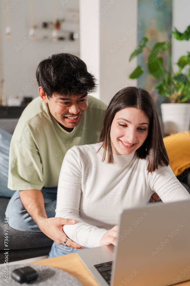 Young woman sitting on a sofa and using a laptop, a relaxed and focused moment at home Young woman sitting on a sofa and using a laptop, a relaxed and focused moment at home