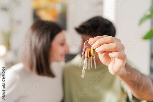 Young couple closely examining a set of house keys, focused and content with their recent purchase photo