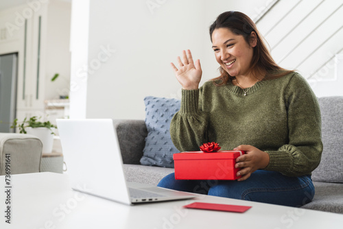 Young plus size biracial woman enjoys a virtual celebration at home photo