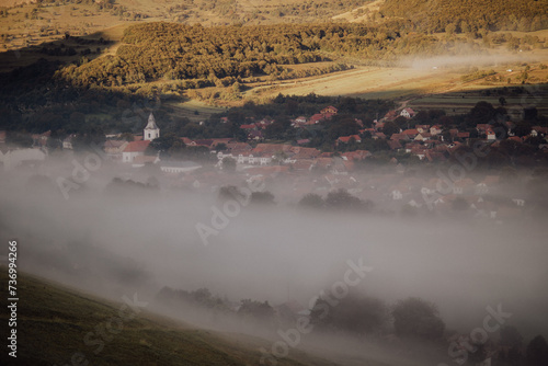 Amazing landscape with Rimetea village covered in fog. Morning