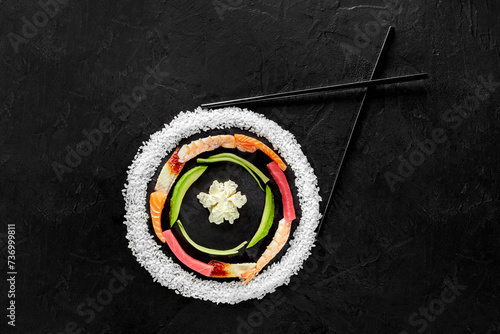 Layered colorful circle of raw sushi ingredients on black