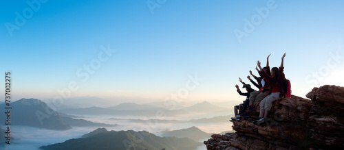 Group of happy hiker raised up arms on the hill photo