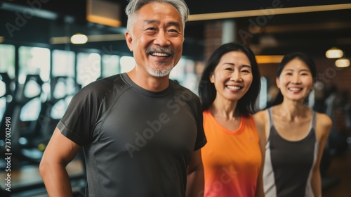 Smiling group older of friends in sportswear laughing together while standing arm in arm in a gym after a workout  senior  healthy  friendship  adult  exercising  together  lifestyles