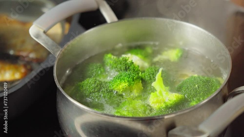 Green broccoli florets simmer and steam up the screen, showcasing a simple yet essential cooking.