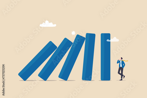 Risk management, uncertainty or unknown threat causing business failure, economic crisis, danger or problem, security and safety concept, courage businessman thinking look at collapsing domino effect.