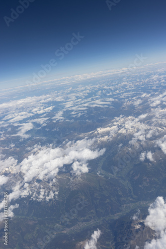 View From The Airplane. Mountains in the distance and Clouds. © Doralin