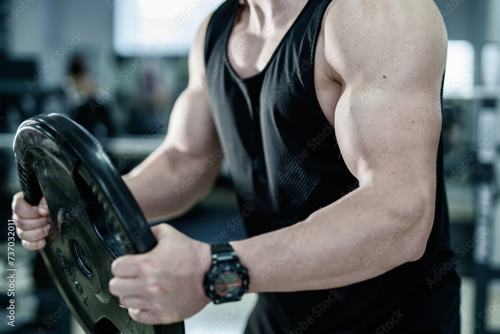 Strong man exercising with dumbbell in the gym Strong man exercising with dumbbell in the gym