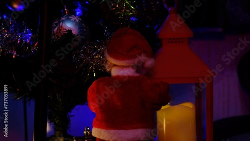 Santa Claus is standing with his back to the tree