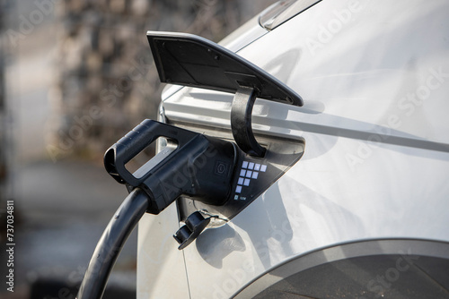 Une voiture électrique connectée à une station de recharge sur un parking © AGDER