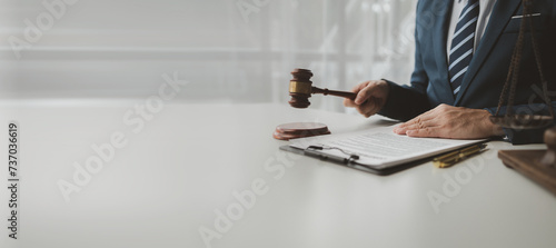 The lawyer sits in his private office, A reliable lawyer is sitting in a firm, The judge is studying information about future cases, concept of justice and law judge in courtroom on wooden table. photo