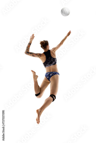 Rear view of young woman, beach volleyball player hits ball in motion against white studio background. Concept of sport games, movement, championship, power and strength, dynamic and energy. © Lustre Art Group 