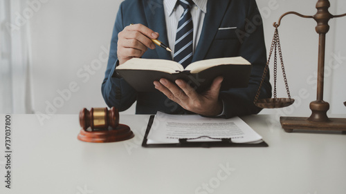 The lawyer sits in his private office, A reliable lawyer is sitting in a firm, The judge is studying information about future cases, concept of justice and law judge in courtroom on wooden table. photo