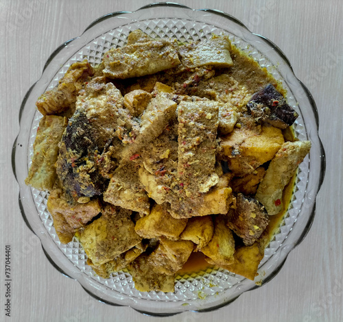 Mangut Ikan Tongkol or spicy fish curry is Javanese cuisine. Smoked tuna fish cooked with tempeh, tofu, spices and coconut milk. Focus selection. Top view.
 photo